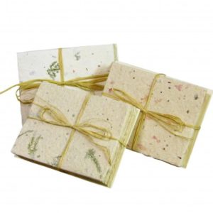 Four handmade Plantable Seed Paper Stationery gift packages tied with natural twine, each embedded with floral and leaf particles, on a white background.